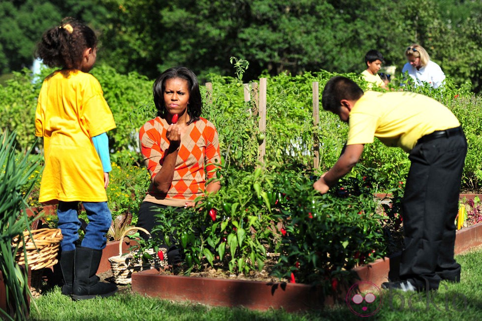 Michelle Obama junto a dos niños en la recogida de la cosecha en la Casa Blanca