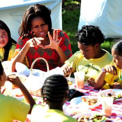 Michelle Obama charla mientra come con unos niños tras recoger la cosecha en la Casa Blanca