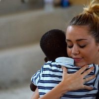 Miley Cyrus abraza a un niño durante su visita a Haití