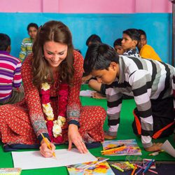 Kate Middleton pinta con un niño en Nueva Delhi