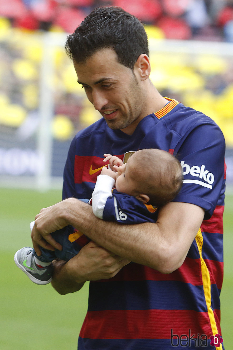Sergio Busquets con su hijo Enzo en brazos en el Camp Nou