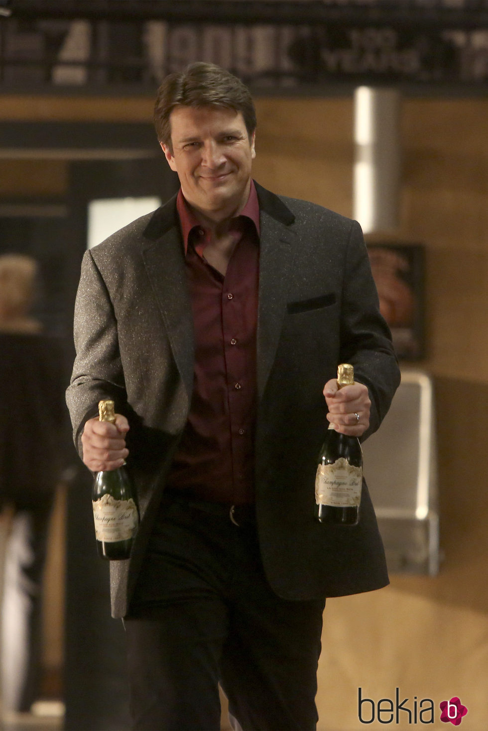 Nathan Fillion con dos botellas de champán en la octava temporada de 'Castle'