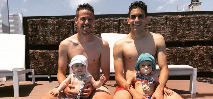 Manu Hervás con su hijo Lars y Marc Bartra con su hija Gala en la piscina