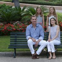 Los Reyes Felipe VI y Letizia con sus hijas en un banco de los jardines de Marivent