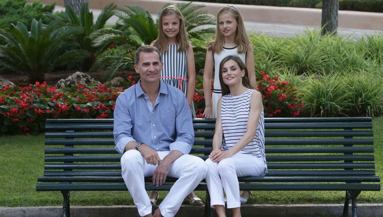 Los Reyes Felipe VI y Letizia con sus hijas en un banco de los jardines de Marivent