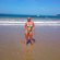 Belén Esteban posando en la orilla de la playa con un bikini print tropical