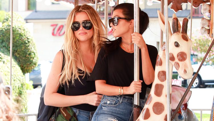 Kourtney Kardashian y Khloe Kardashian montando en un tiovivo en California