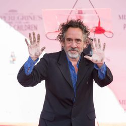 Tim Burton motrando sus manos tras dejar sus huellas frente al Teatro Chino de Hollywood